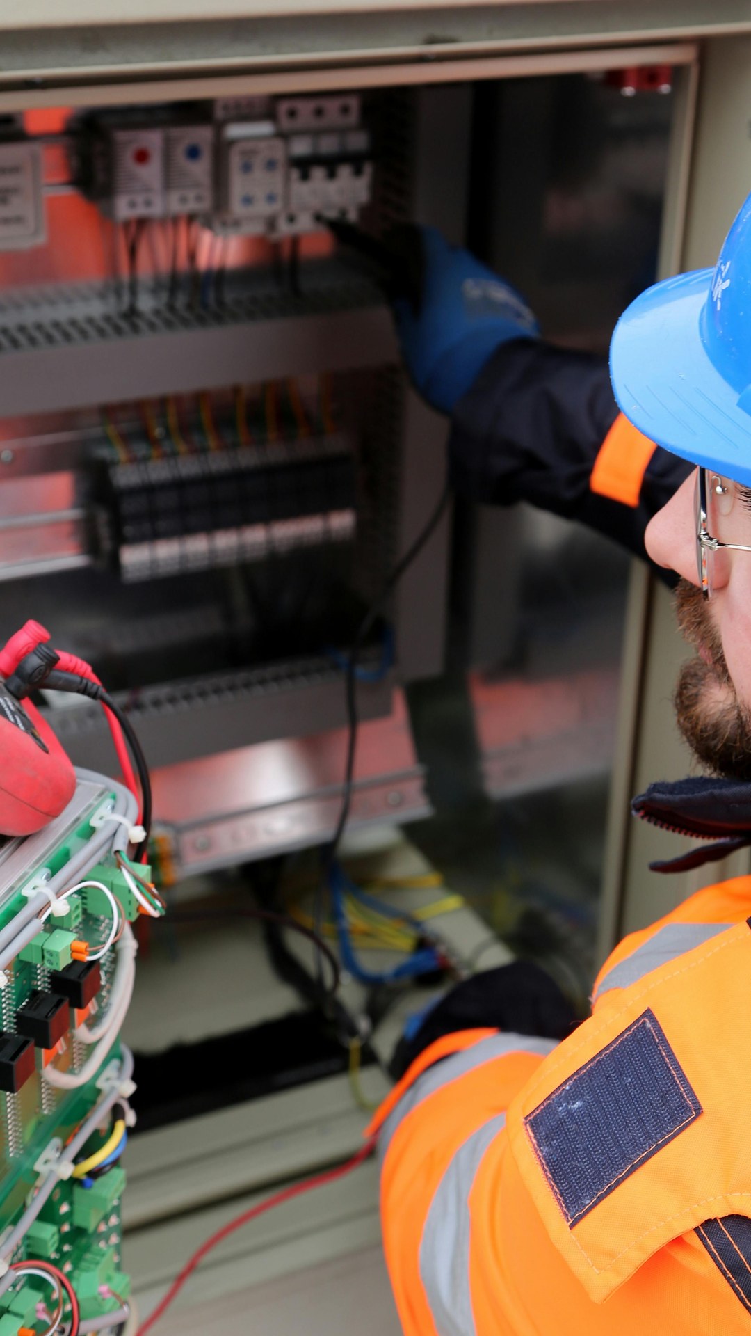 Eletricista com equipamento de proteção operando quadro elétrico, ilustrando o padrão de cuidado da WG Instalações Elétricas